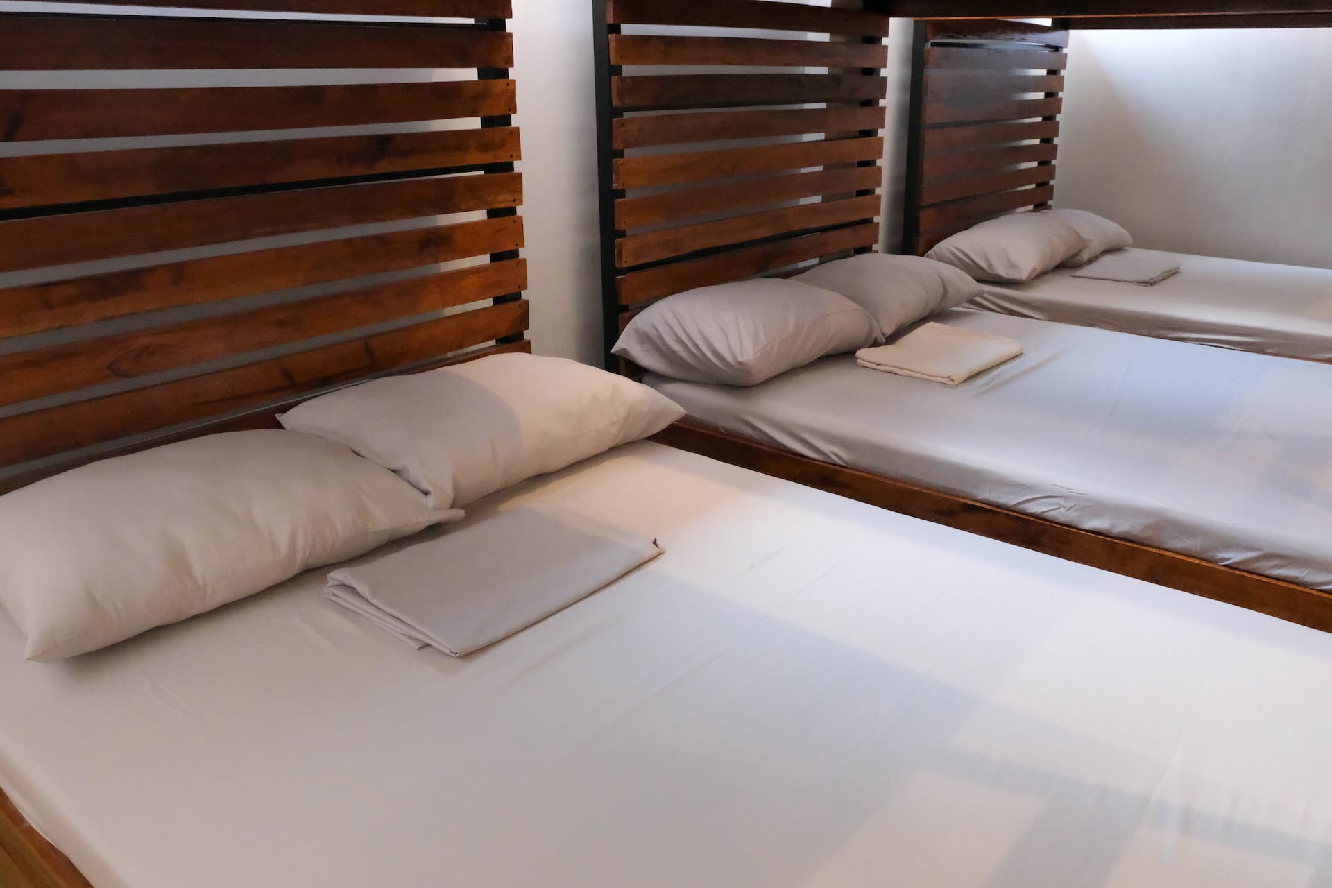 Lower Bunk Bed Pods with Crisp White Linens & Slatted Headboards