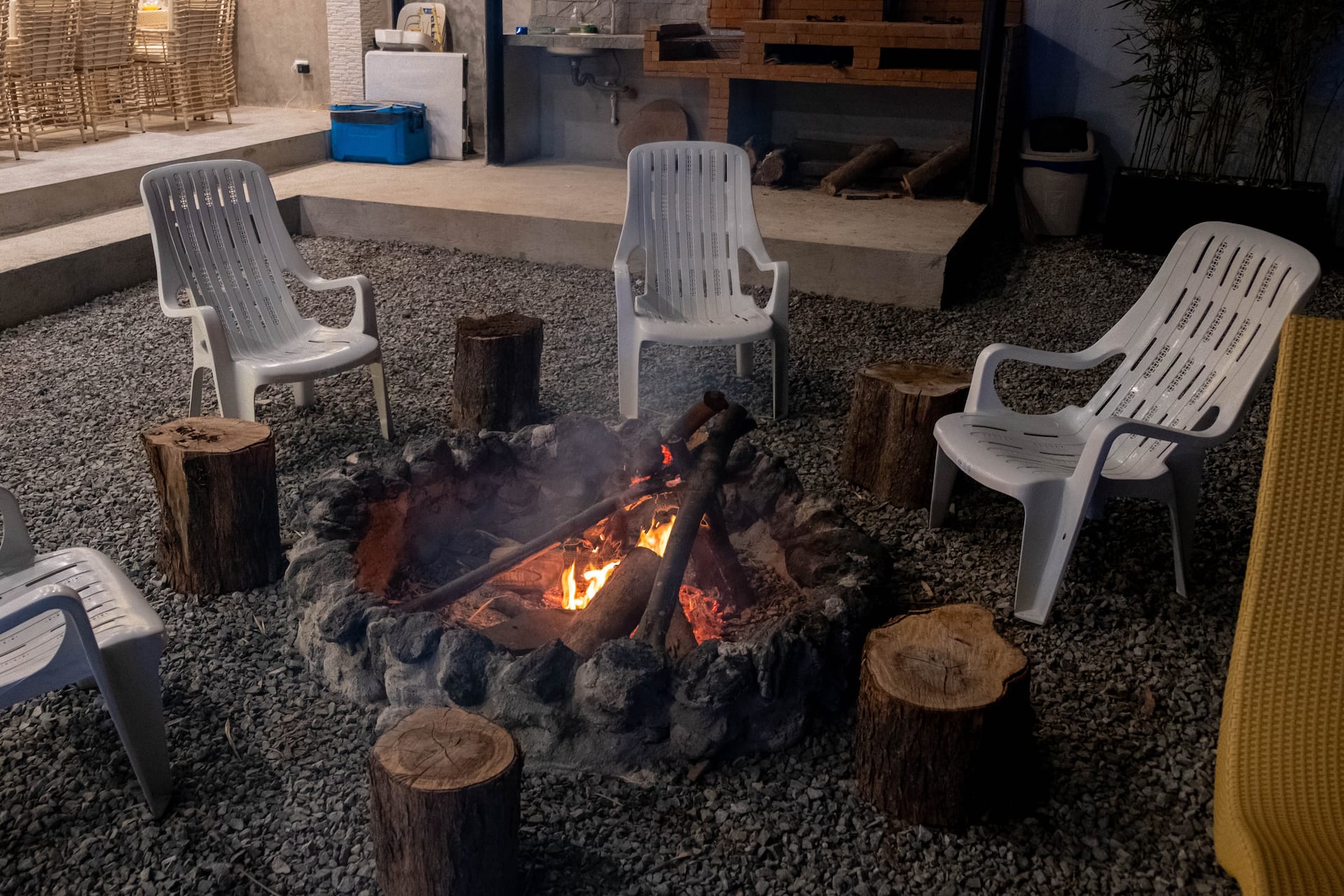 Outdoor Bonfire Pit with Burning Logs & Tree Stump Stools