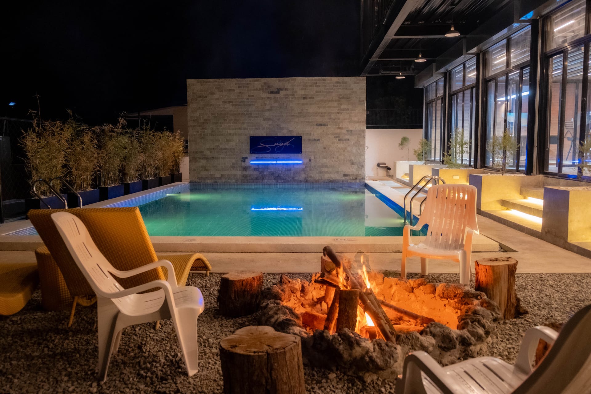 Bonfire Pit & Heated Pool with Cyan Water Feature at Night